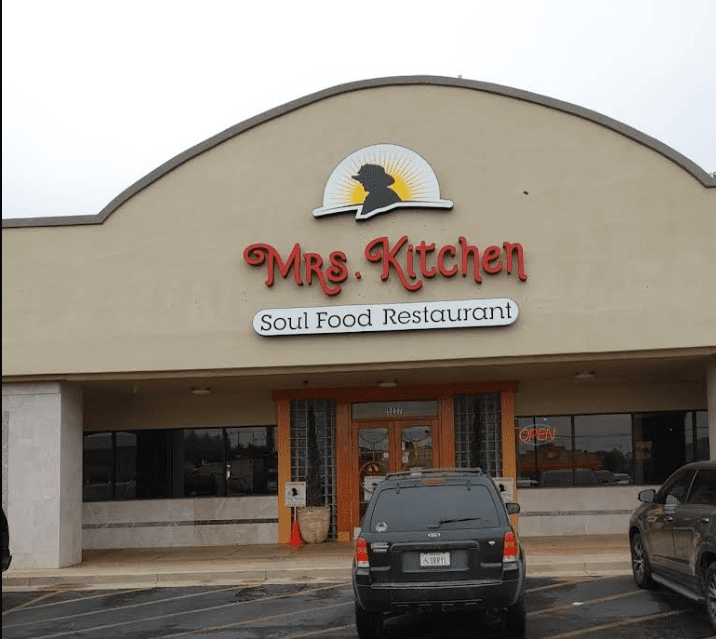 a building with a sign and cars parked in front of it